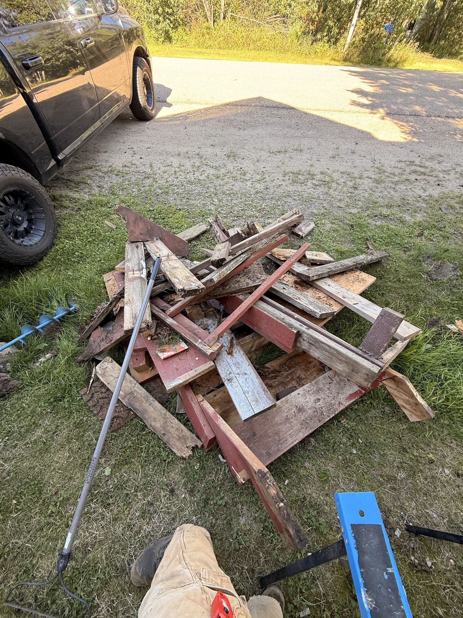 A pile of the old red-painted porch timber on the grass