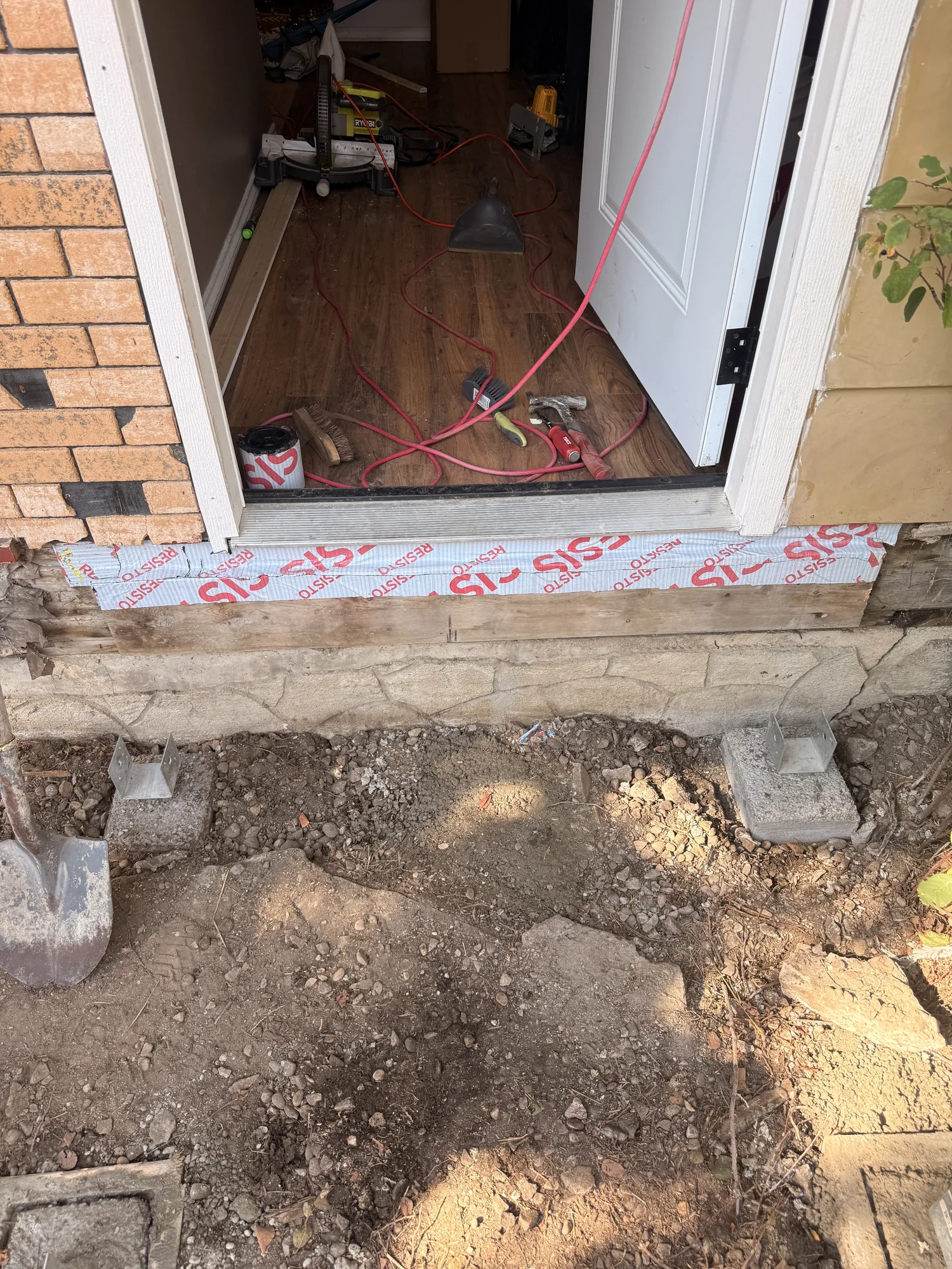The doorway sill with deck blocks set out on the dirt below