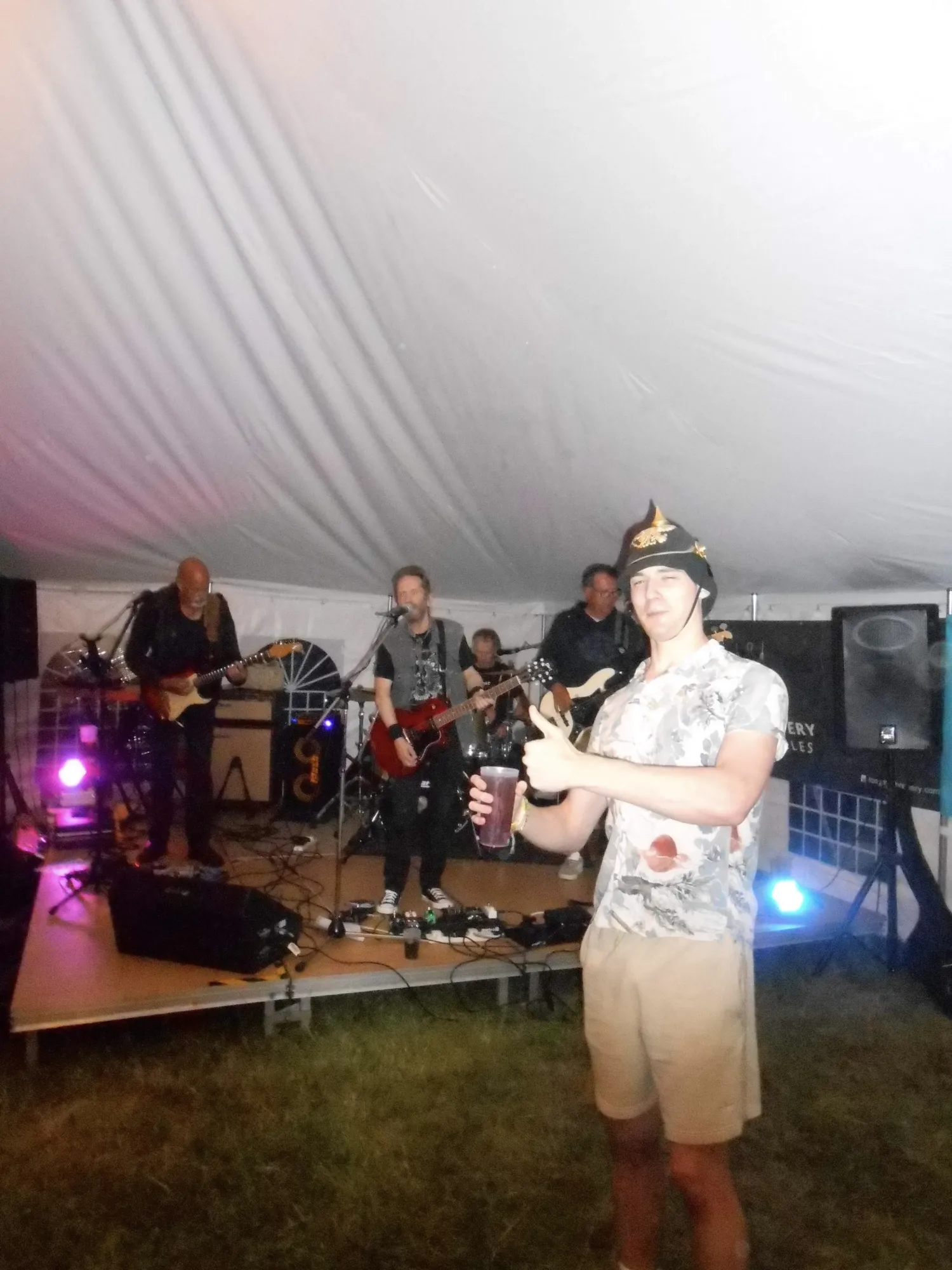 Ryan in front of a live band, thumbs up