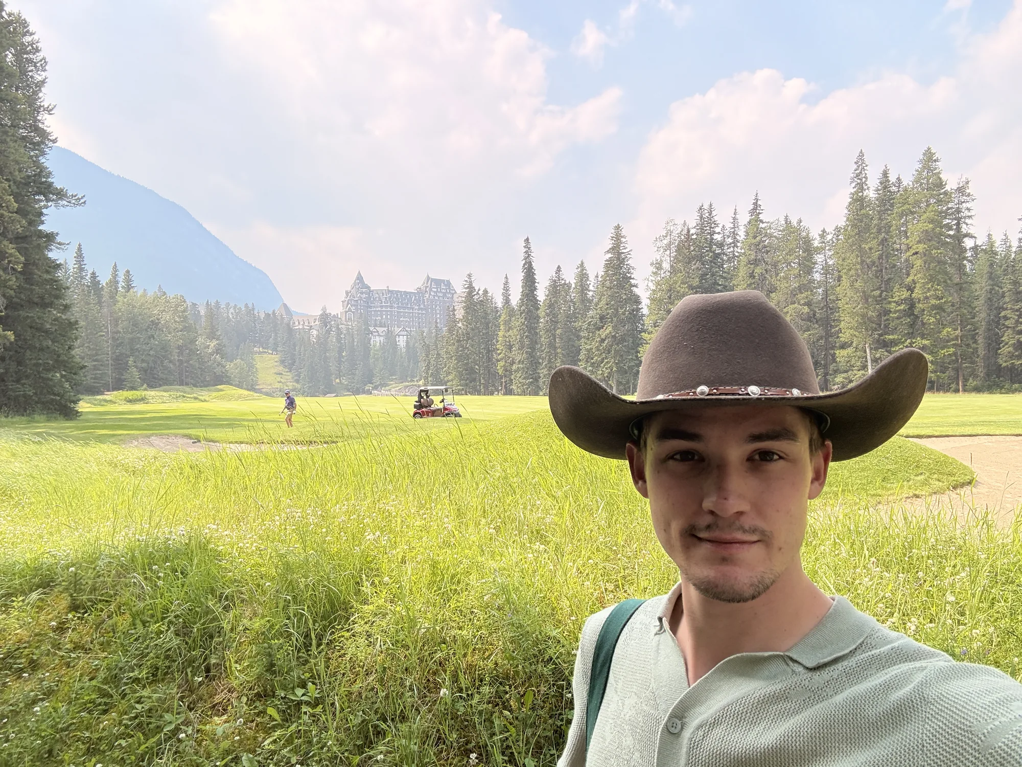 The Banff Springs hotel behind the golf course on a hazy afternoon