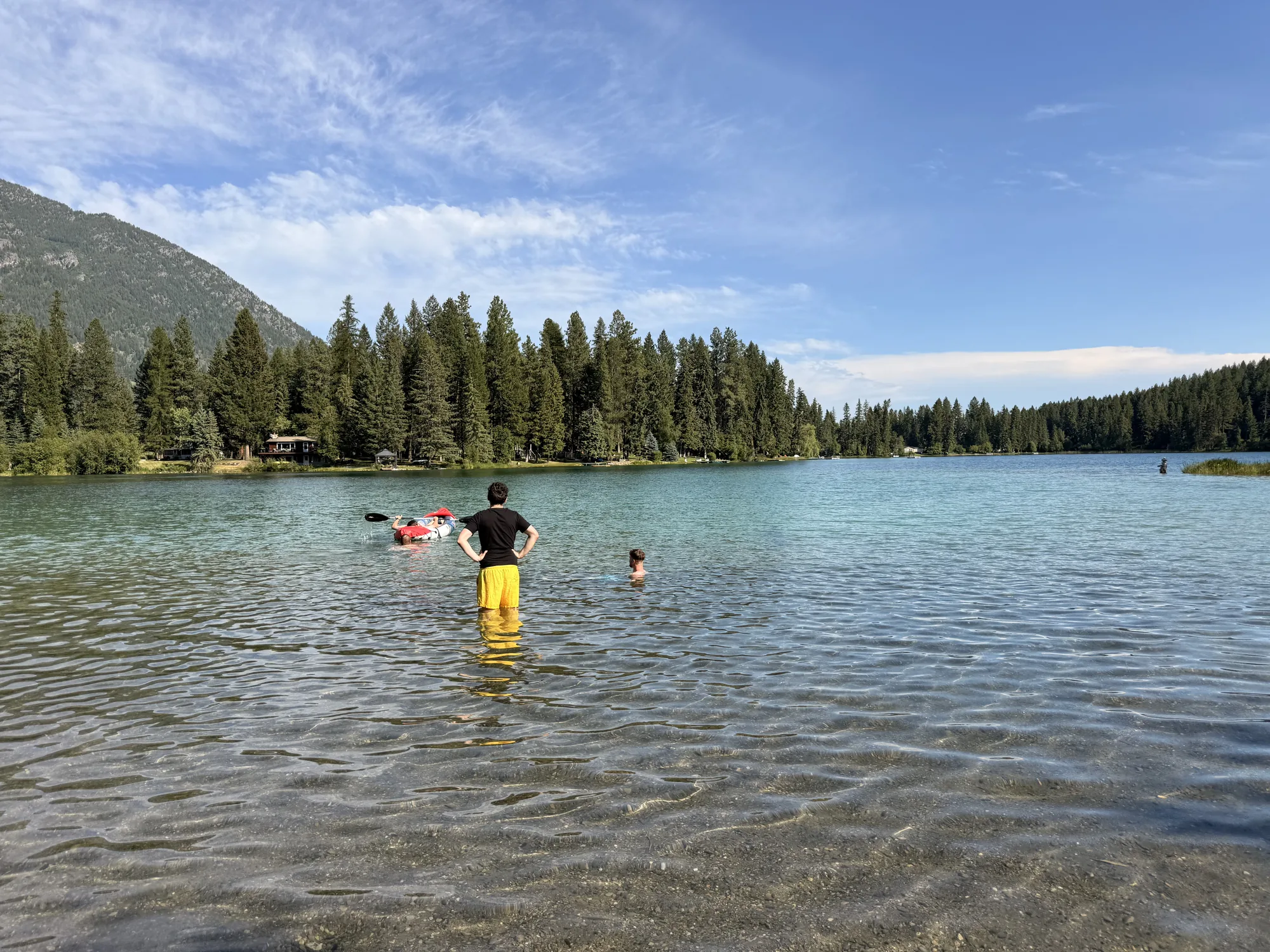 Swimming in the clear green water of Norbury Lake with mountains beyond