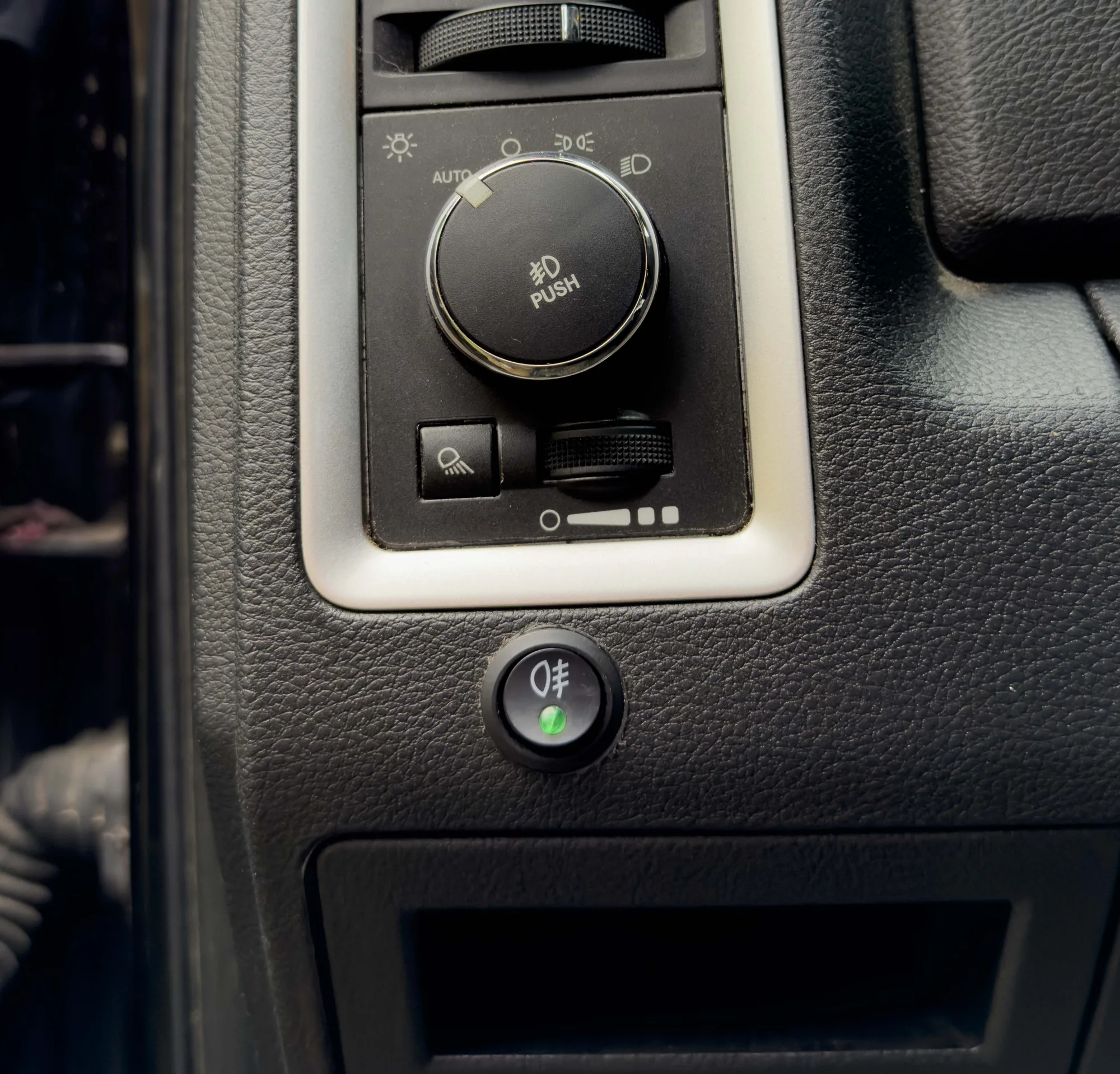 The LED switch wired into the dash, drilled in just below the factory headlight knob