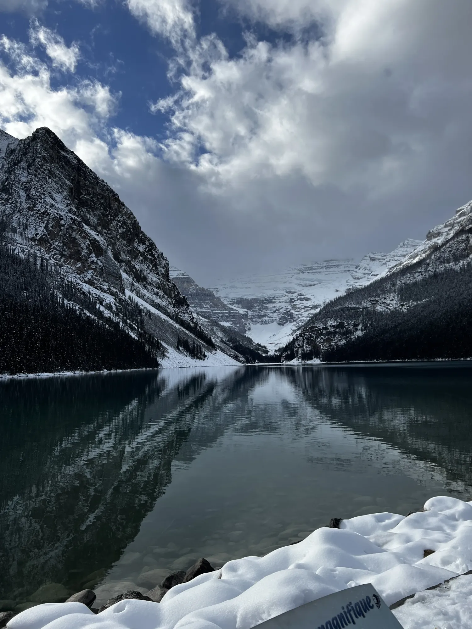 A still mountain lake below snow-dusted peaks in Banff National Park