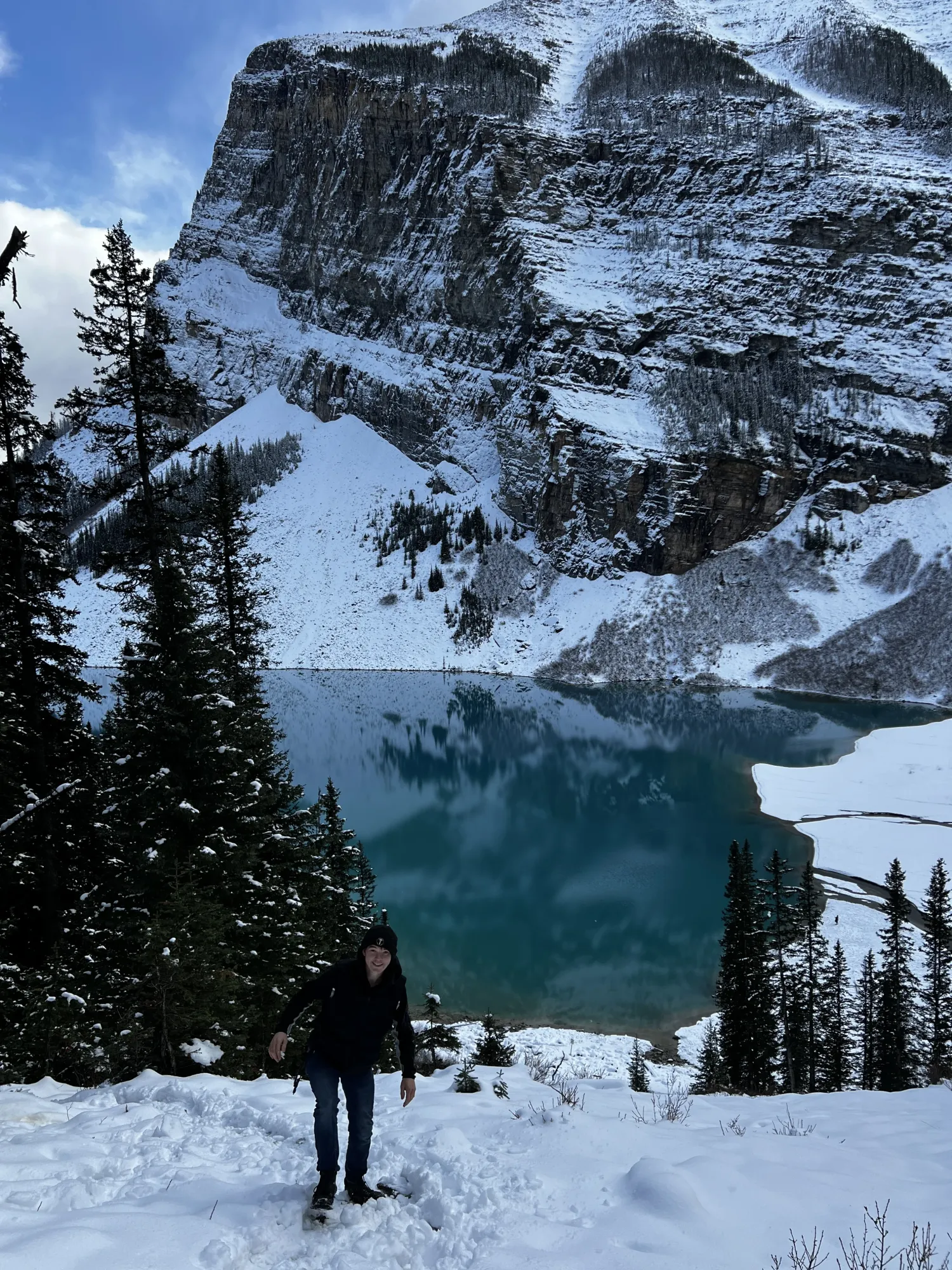 A steep rock face rising above a turquoise lake in Banff National Park